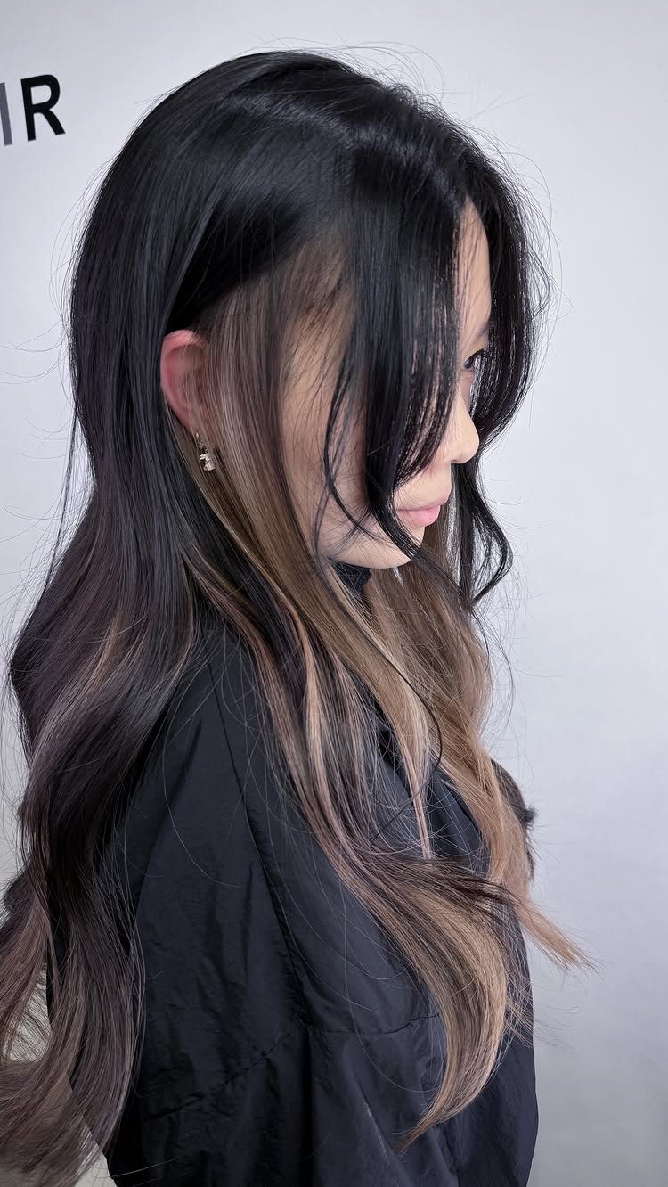 Long dark waves reveal subtle caramel highlights beneath the top layers