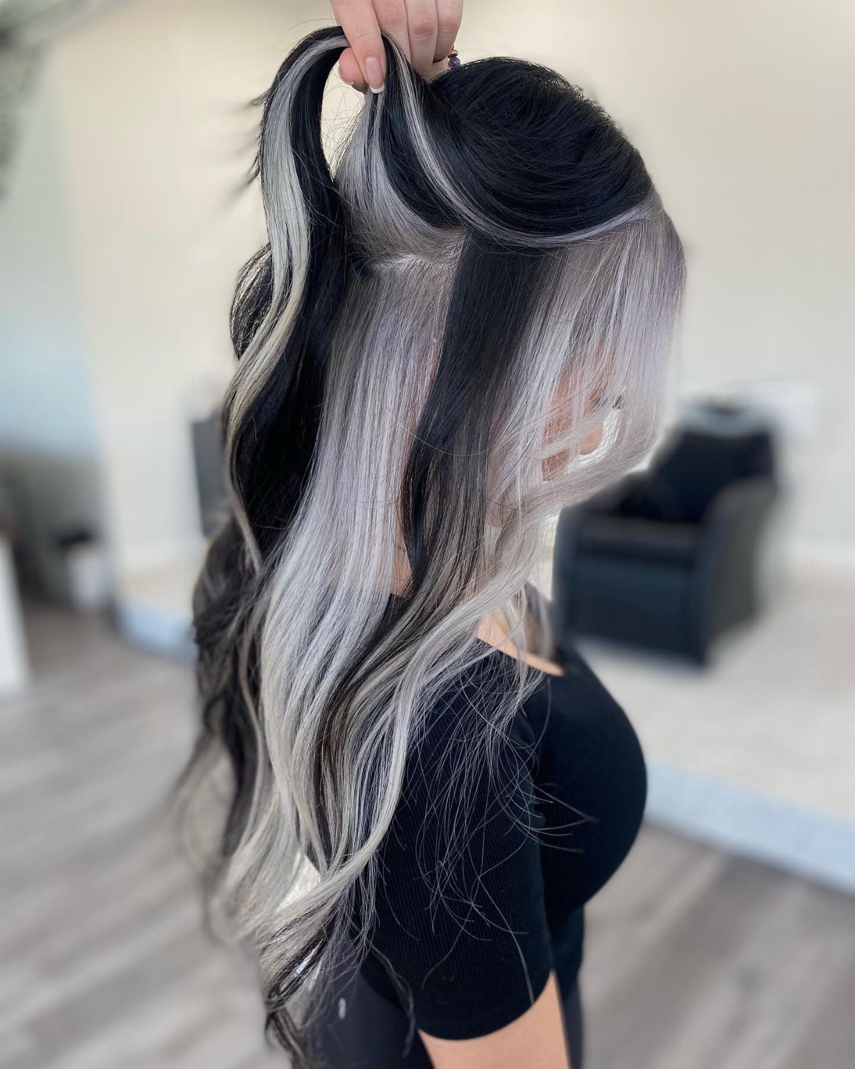 Dark brown hair lifted to reveal broad platinum-silver underlayers in loose waves