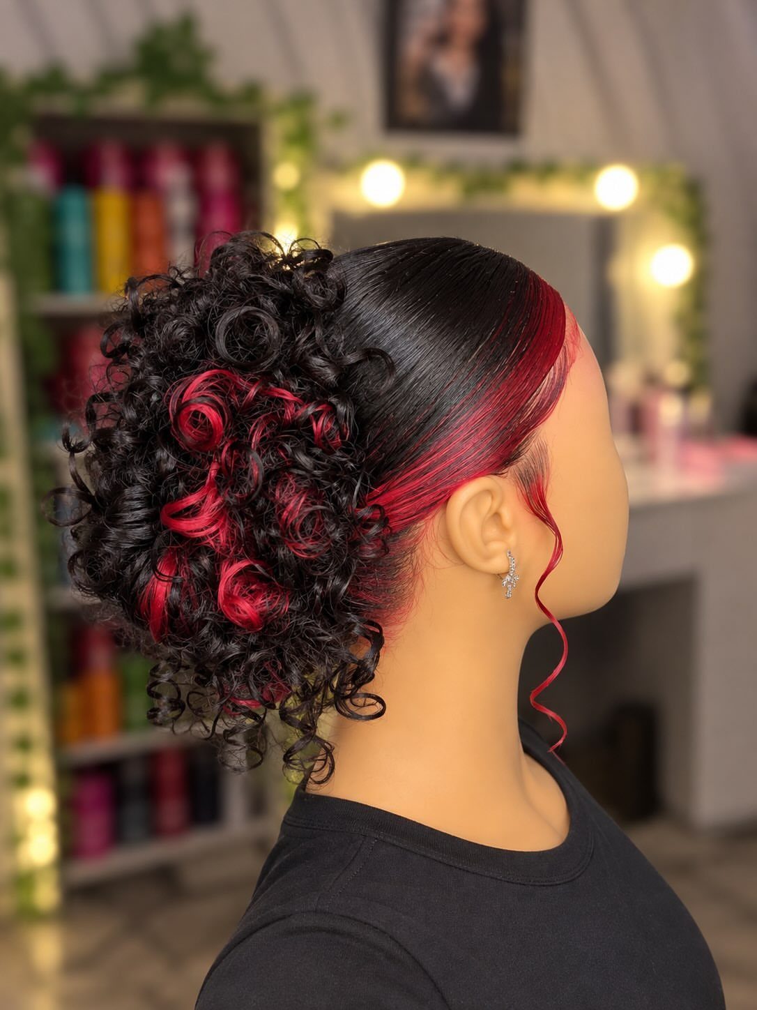 High curly puff with vivid red underlayer sections showing through dark hair