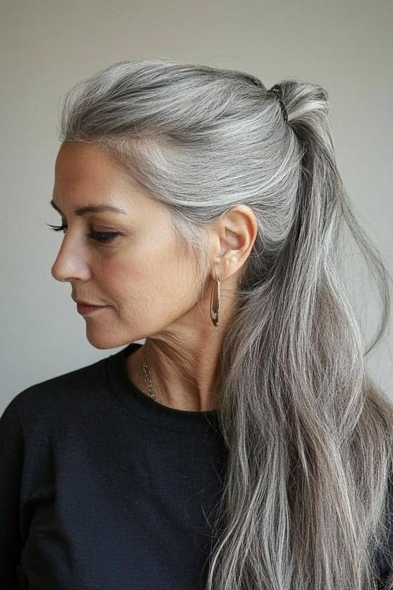 Woman with long straight silver-gray hair in a high ponytail