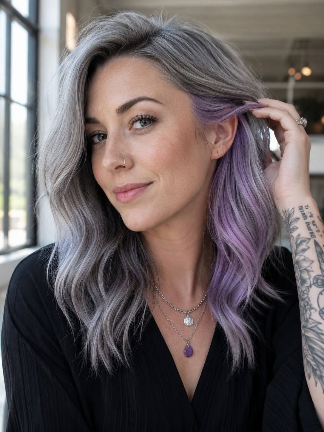 Woman displaying long wavy silver-gray hair with lavender highlights beside her face