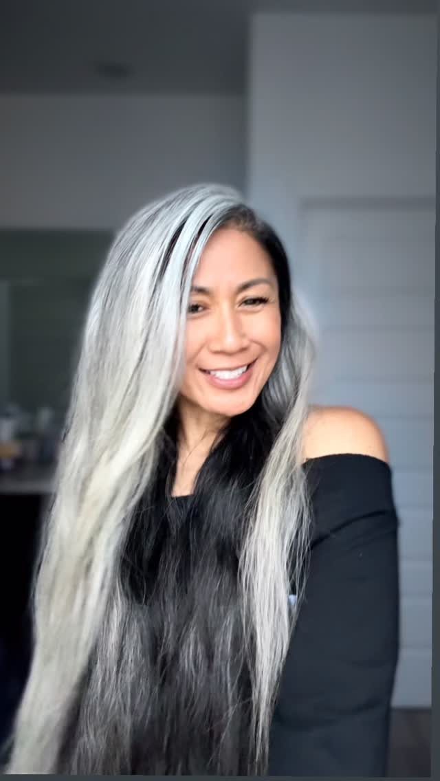 Woman with long dark hair blended with prominent silver-gray highlights