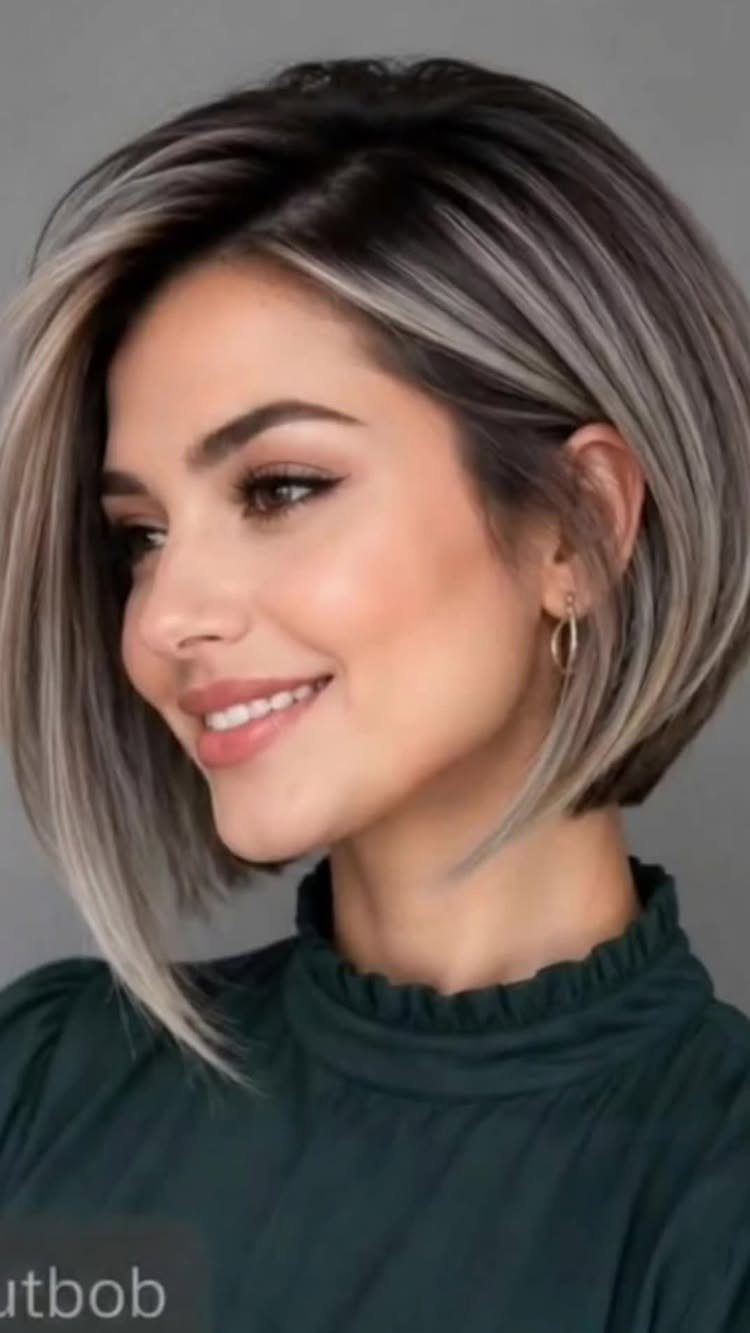 Woman with a short asymmetrical silver-gray bob and dark roots