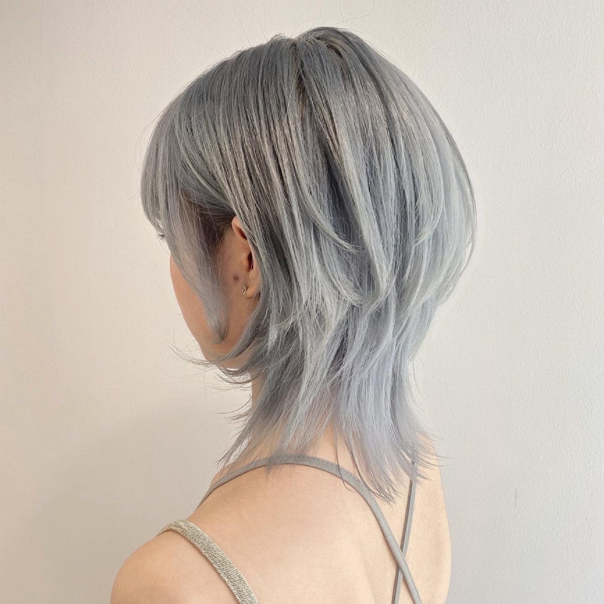 Layered silver-gray haircut with tapered pieces at the nape
