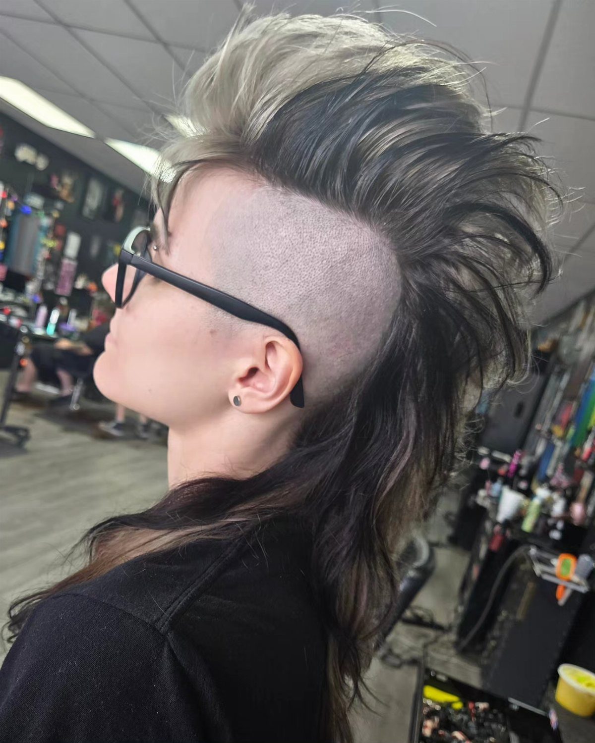 Two-tone gray and beige mullet with a shaved side in a salon