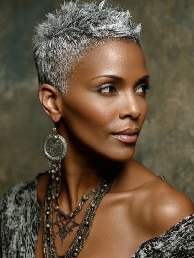 Woman with a short spiky silver-gray haircut and dangling earrings