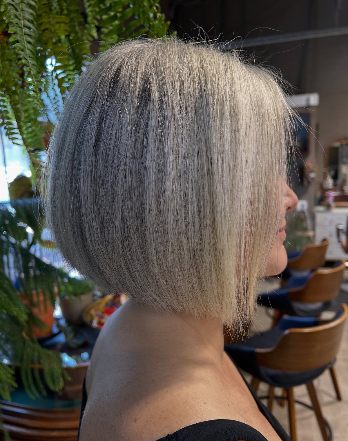 Straight silver-gray bob with long face-framing pieces in a salon