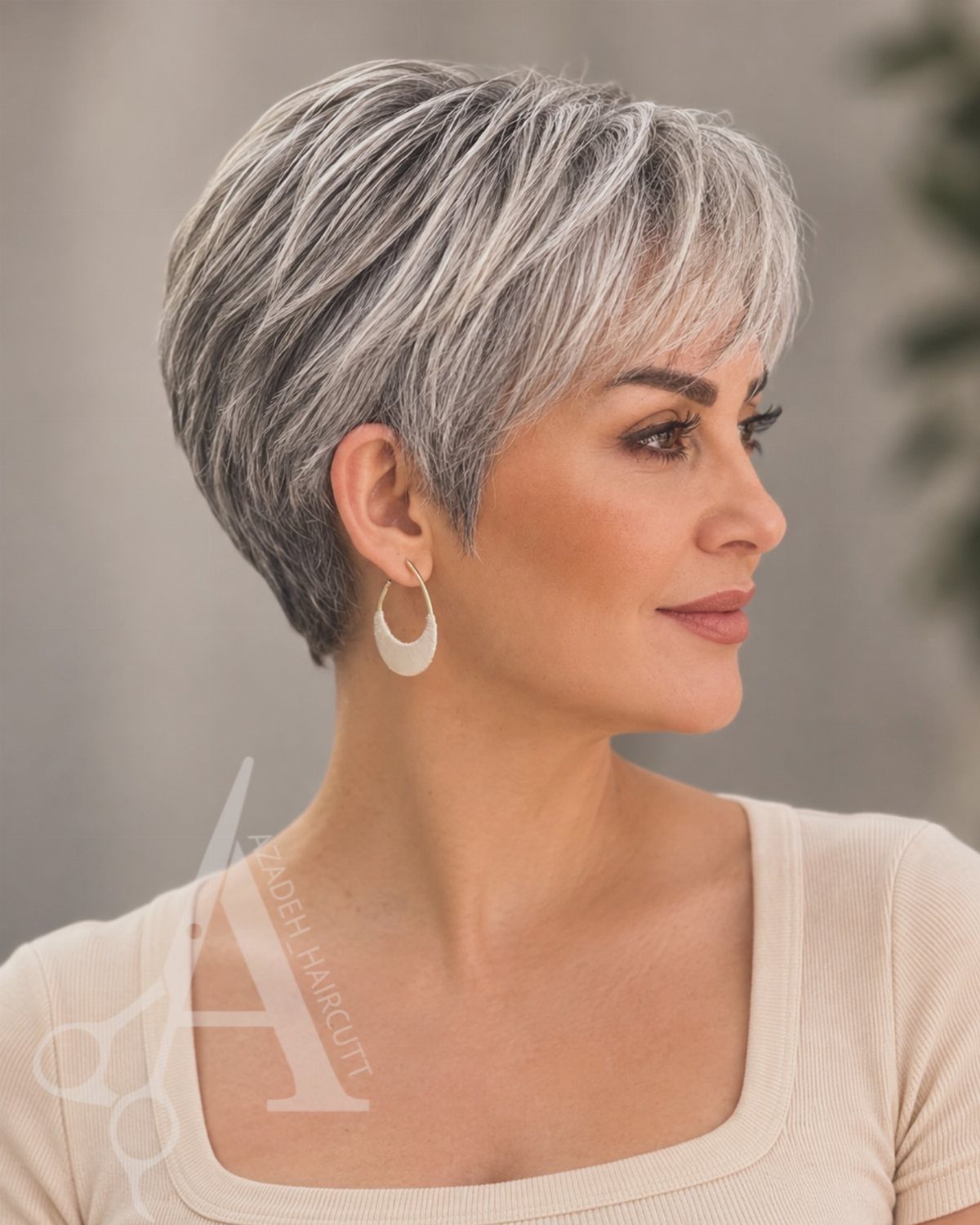 Woman with short layered silver-gray hair and side-swept fringe