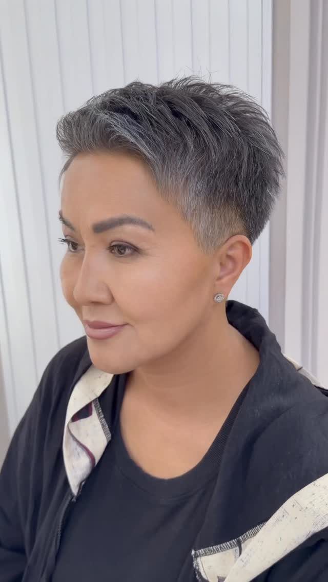 Woman displaying a short, swept-back grey pixie hairstyle