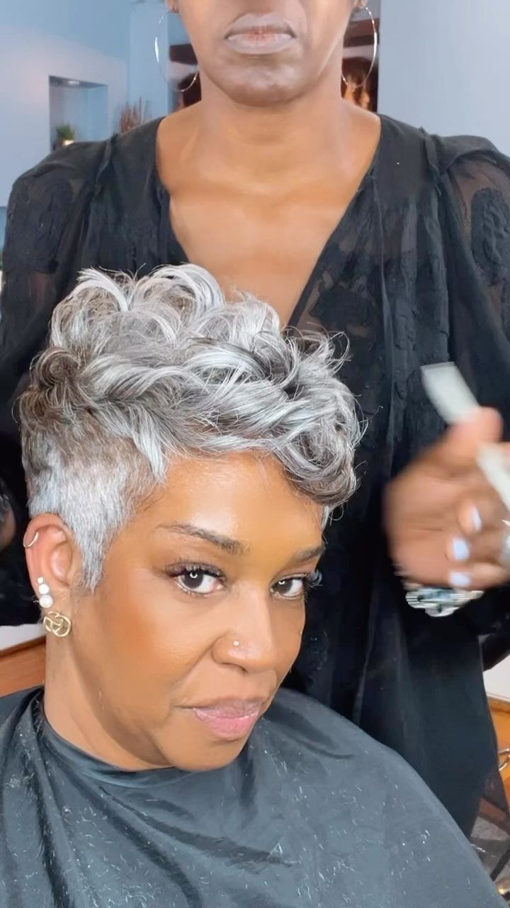 Woman with voluminous silver-gray curls styled in a short pixie cut