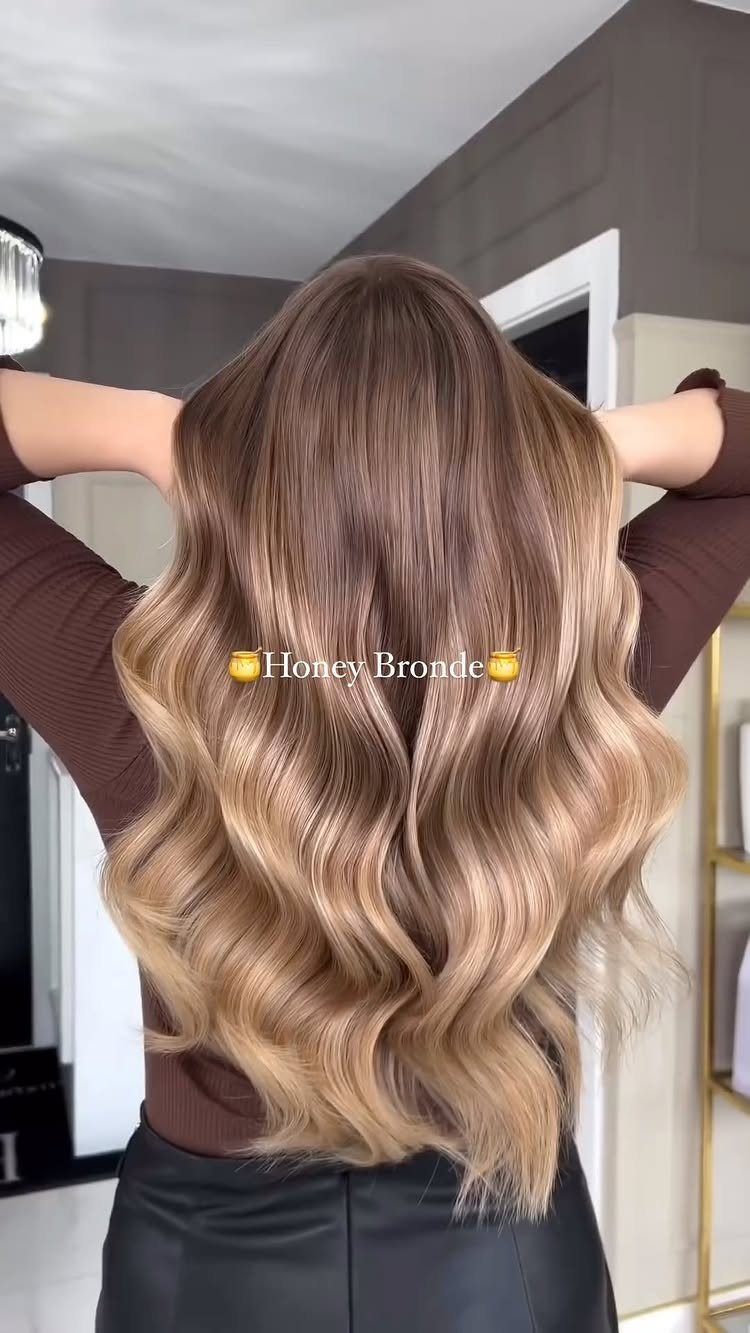 Long wavy bronde hair blends brown roots with warm blonde lengths