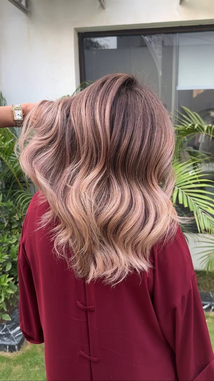 Wavy mushroom blonde hair with muted brunette tones and lighter ends