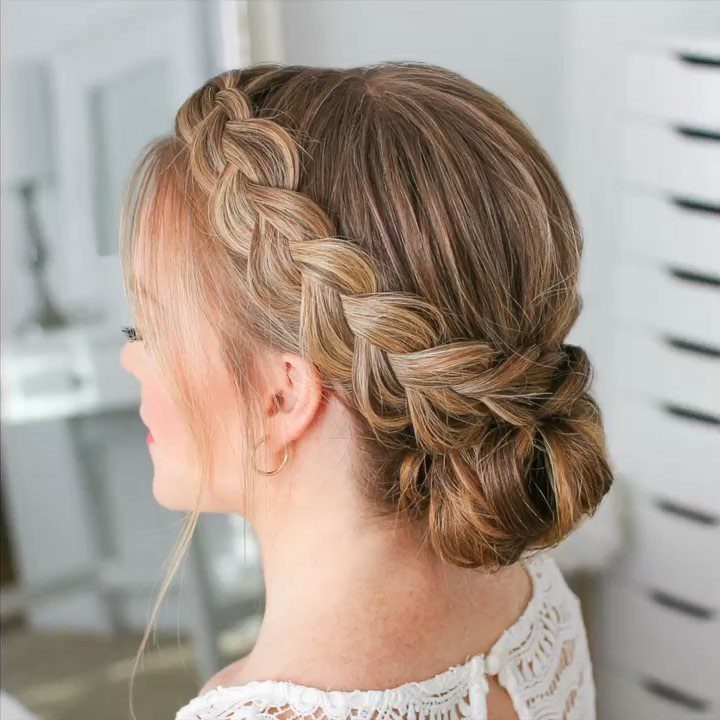 Dutch braid woven around the head and tucked into a low bun