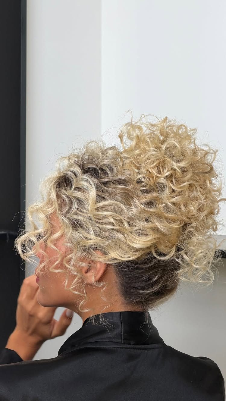 Blonde curly faux hawk updo swept high above the nape