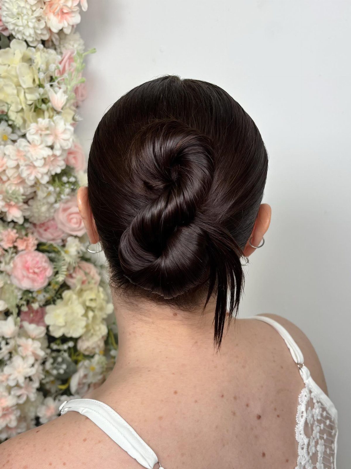 Figure-eight bun formed from two smooth loops on the back of a woman's head