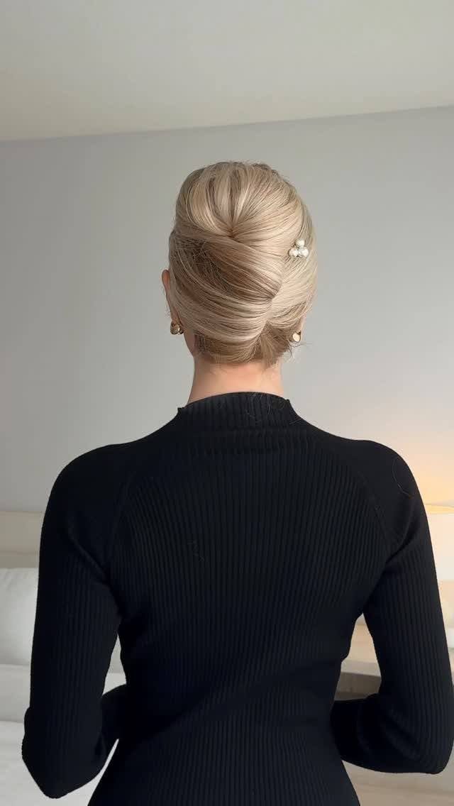 Blonde French twist pinned neatly with pearls at the back of her head