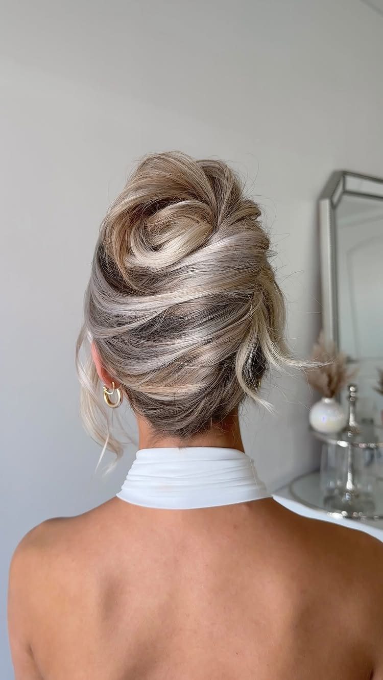 Textured French pleat with loose strands on a woman seen from behind