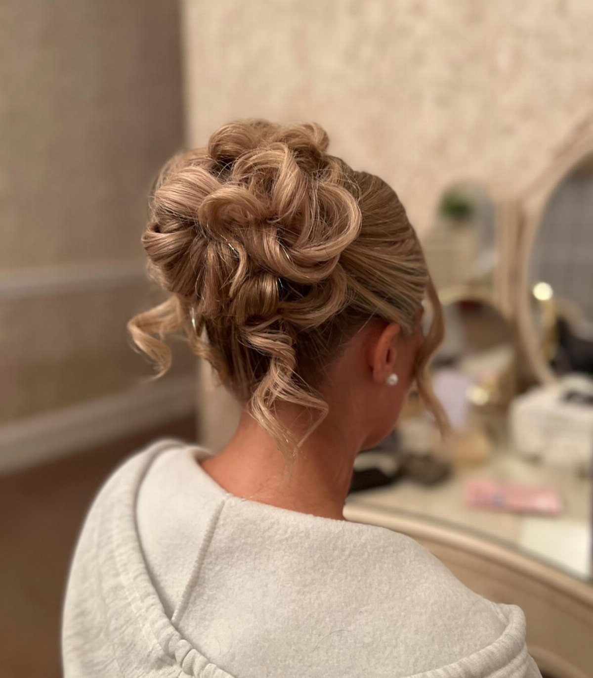 Pinned curled updo gathered into a voluminous bun at the nape