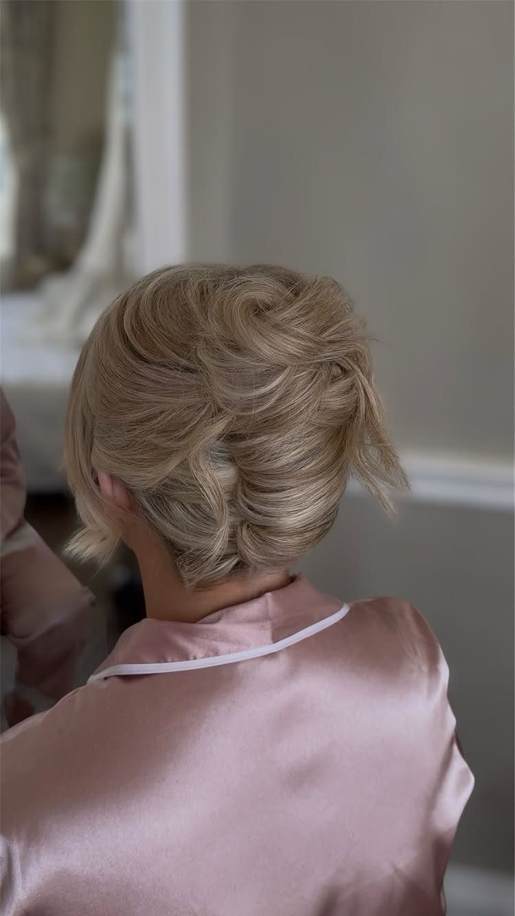 Short blonde hair styled into a soft, textured pinned updo
