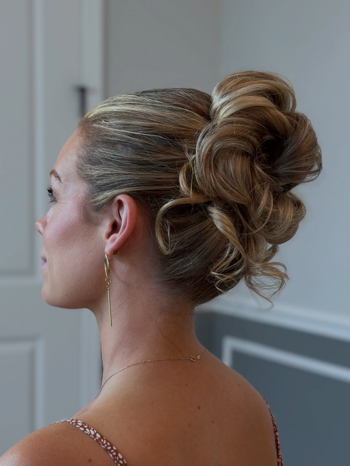 Woman wearing a soft, voluminous low updo with curled, textured strands