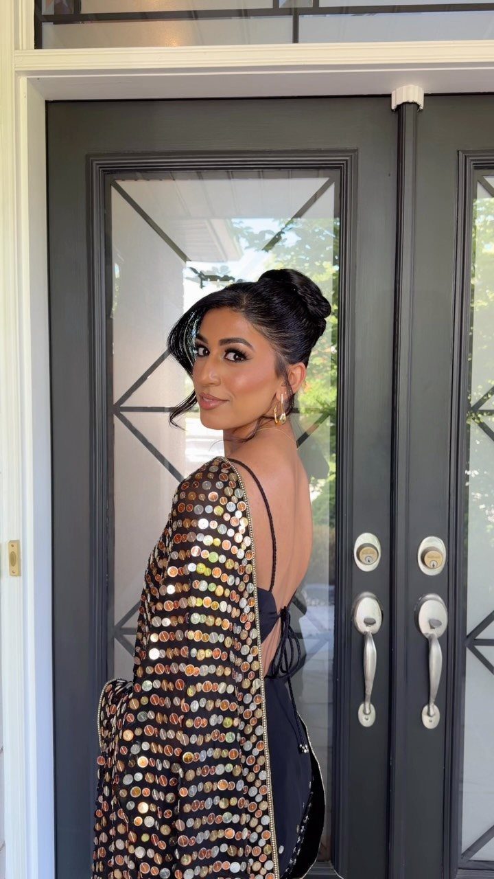 Woman in a black embellished dress showing her sleek pinned updo