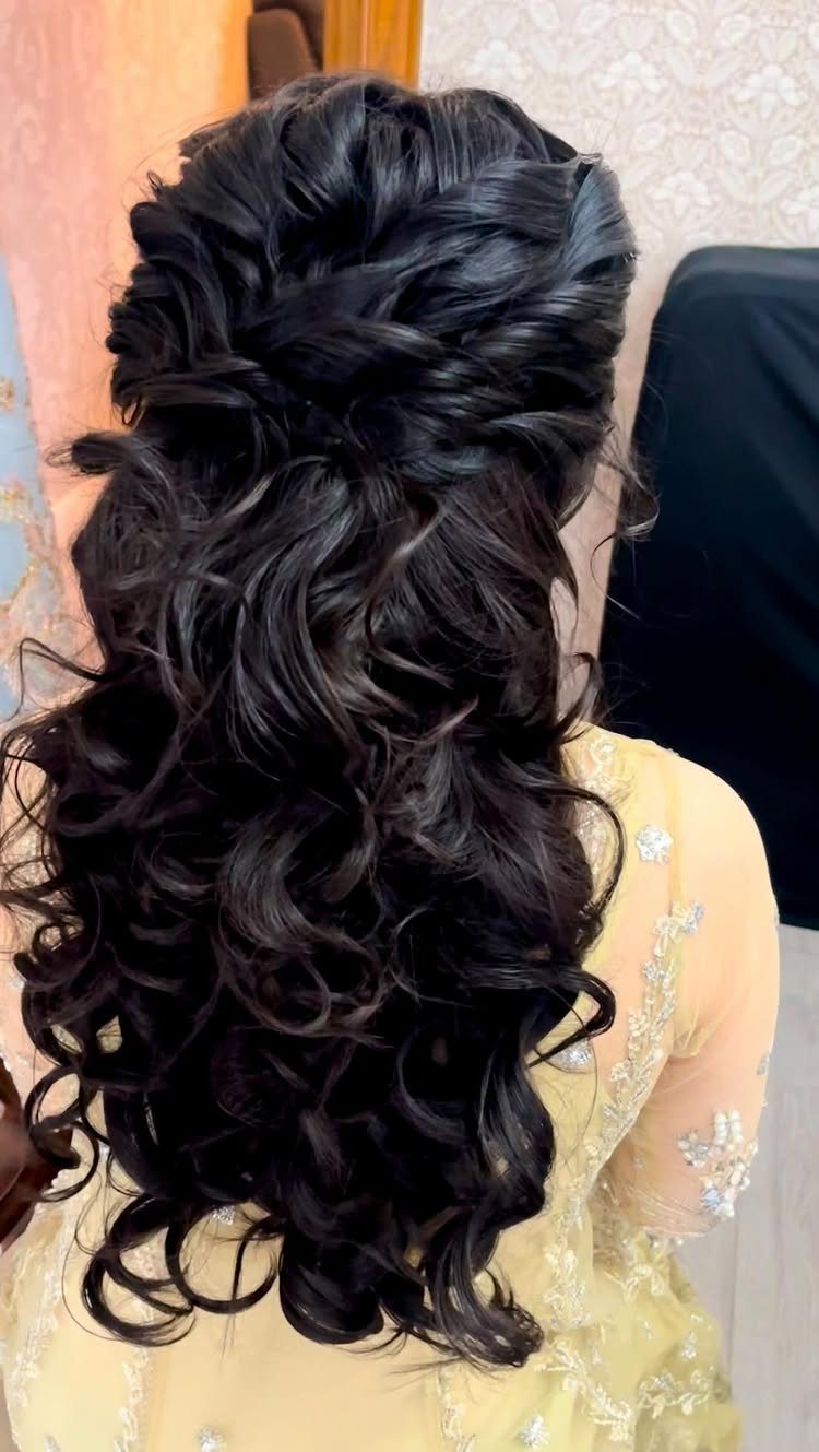 Long dark tousled curls styled with a twisted, pinned upper section