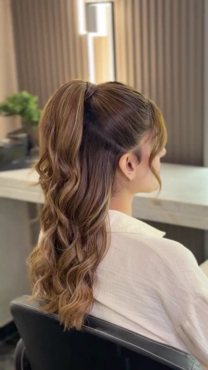 High brown ponytail with loose curls through the ends in a salon