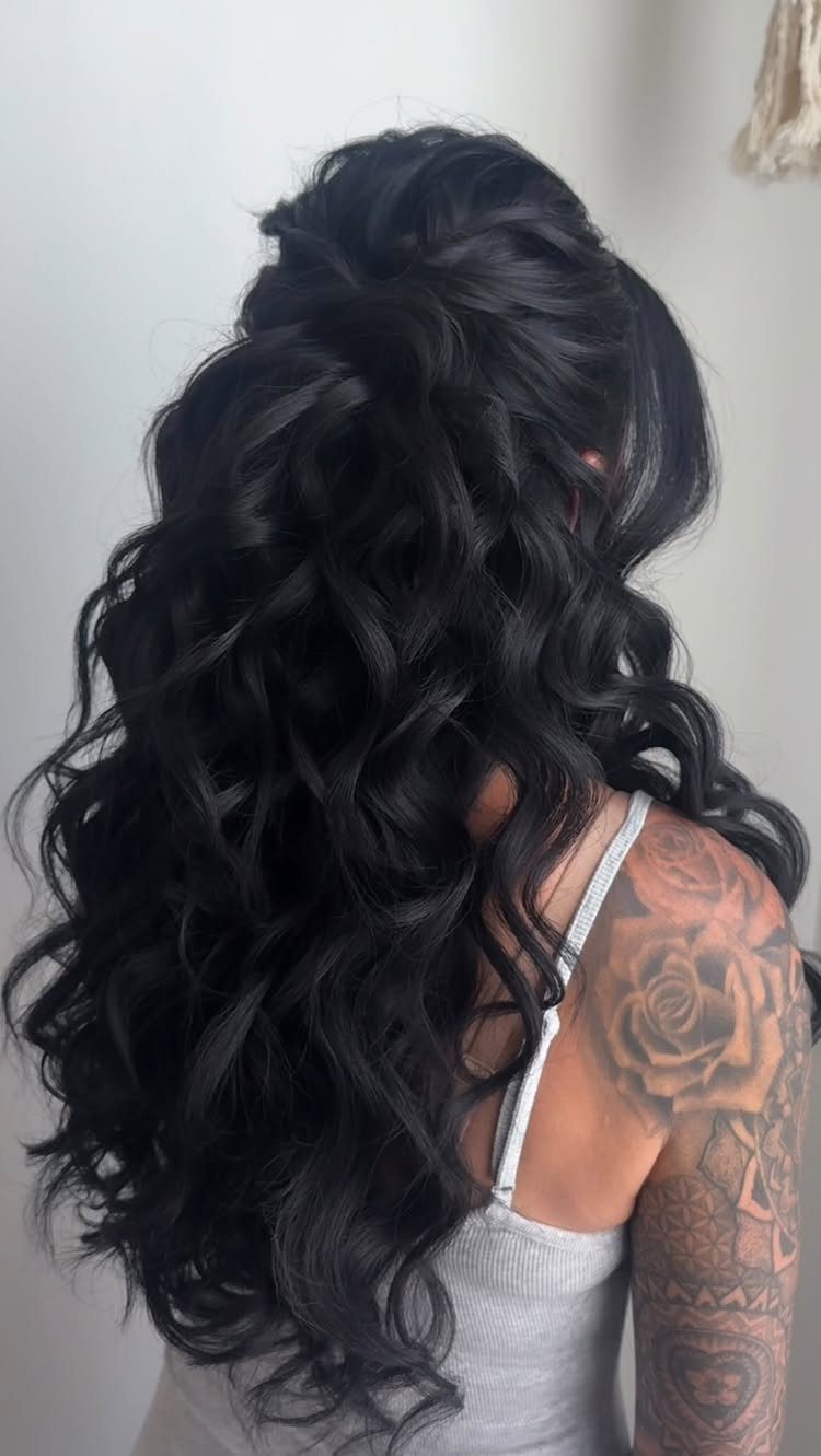 Long dark curls styled half up and half down on a woman