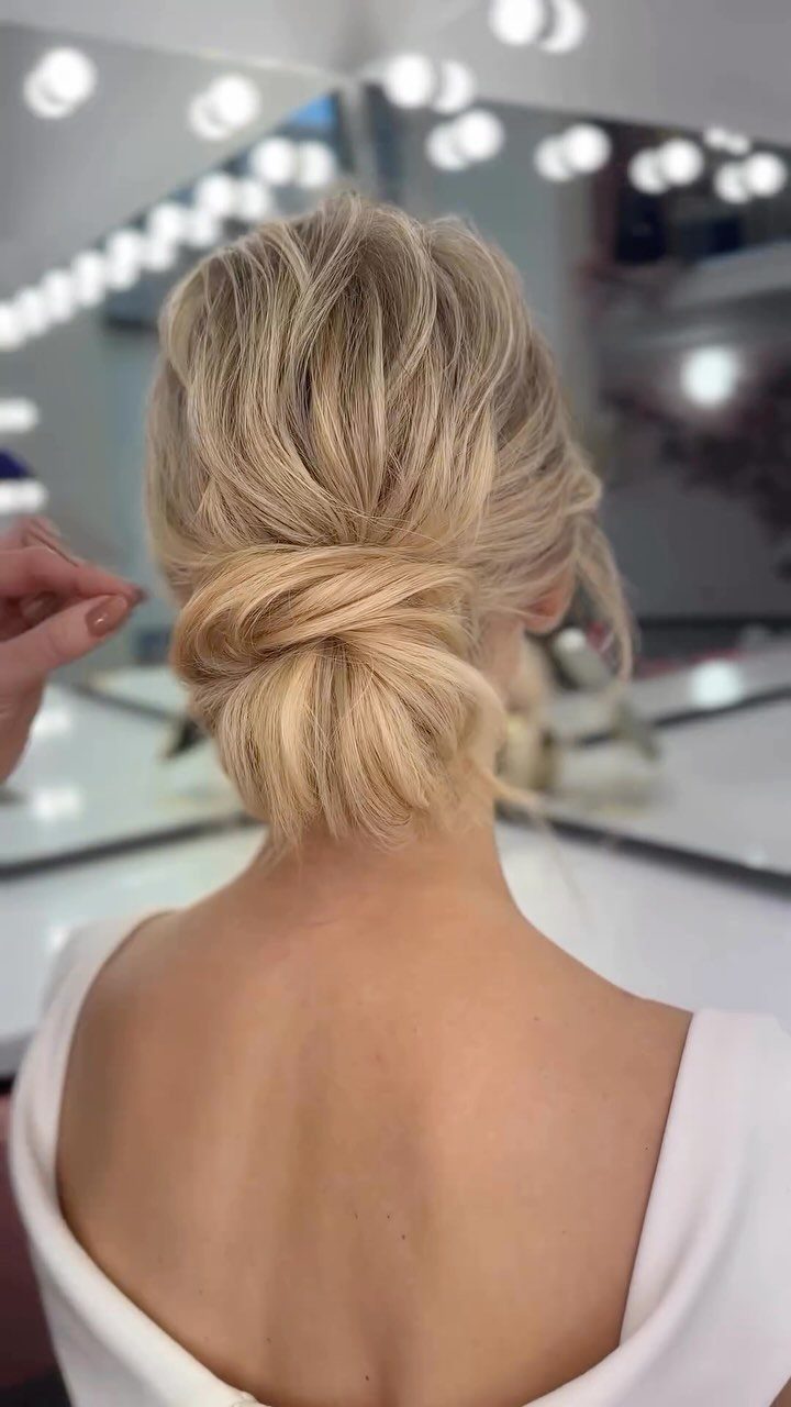 Blonde woman wearing a textured twisted low bun in a salon