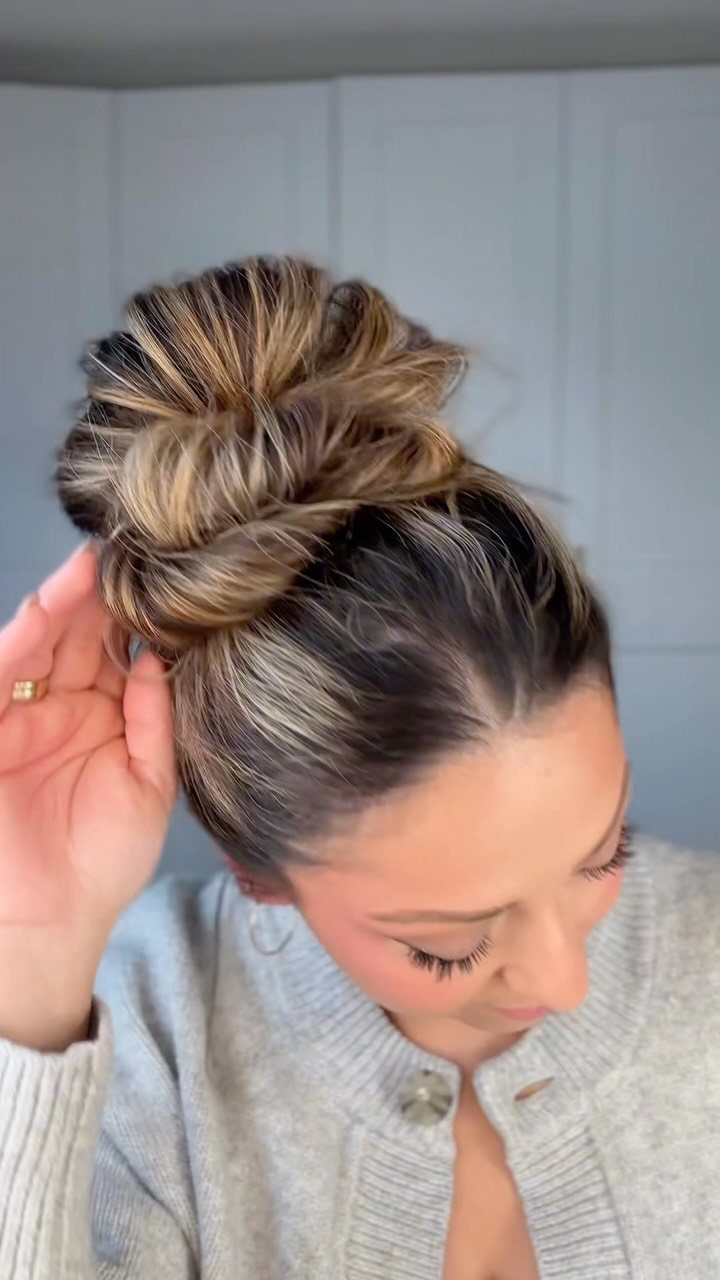 Loose textured bun with highlighted hair gathered high on a woman's head
