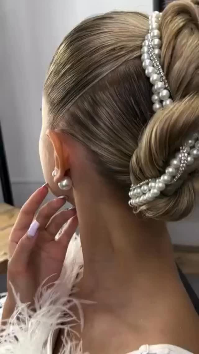 Blonde updo decorated with pearl pins and matching pearl earrings