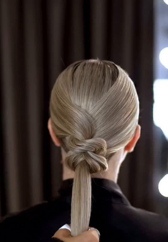 Sleek blonde ponytail with a crossed knot detail above the tail
