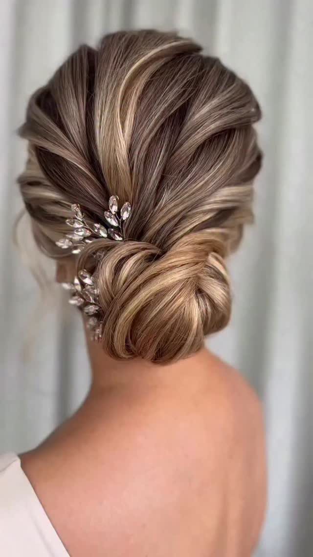Textured low chignon with highlighted twists and jeweled hair pins