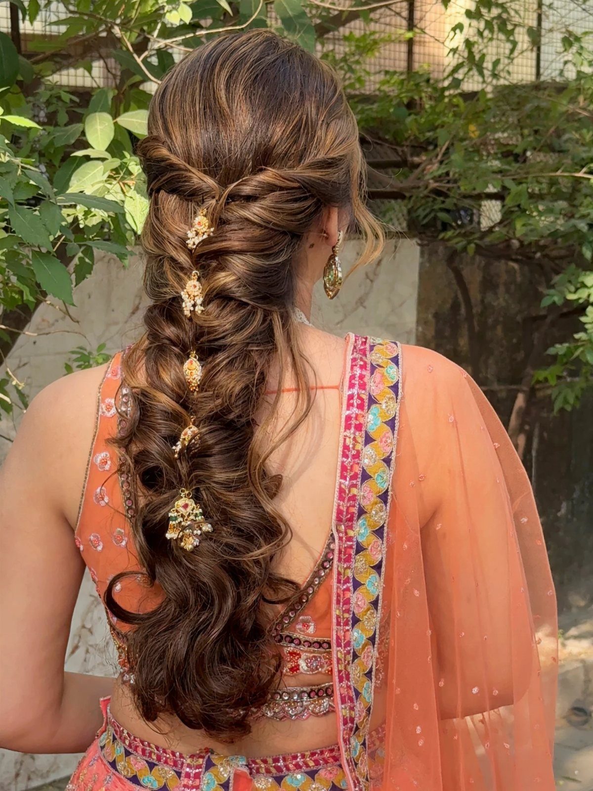 Long textured brown plait with loose curls and gold floral ornaments