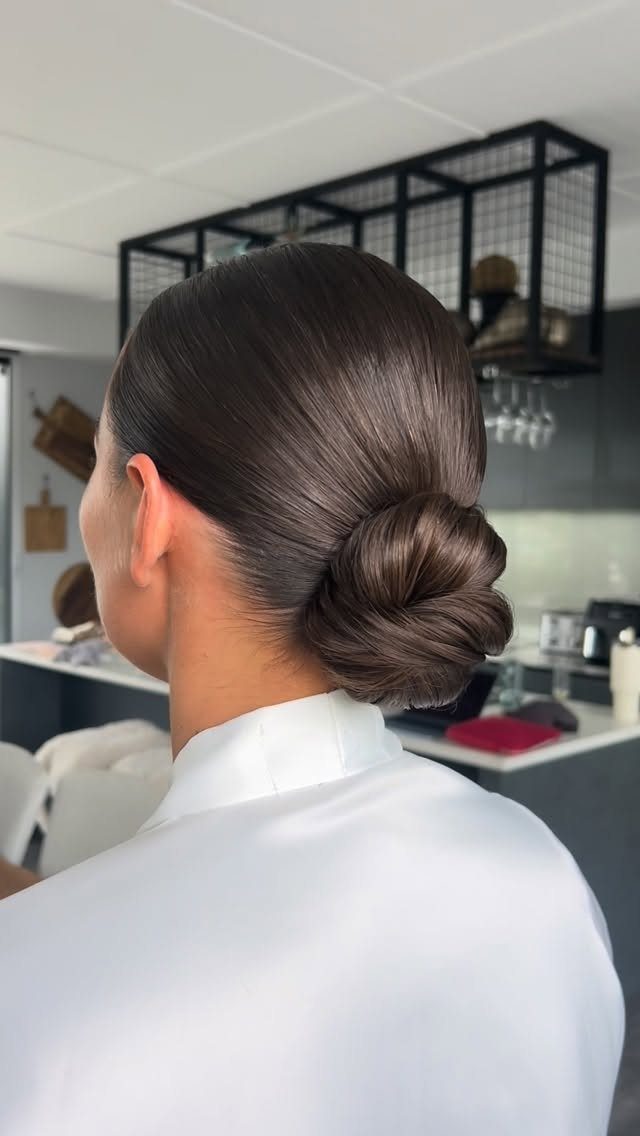 Smooth dark hair arranged in a low twisted knot at the nape