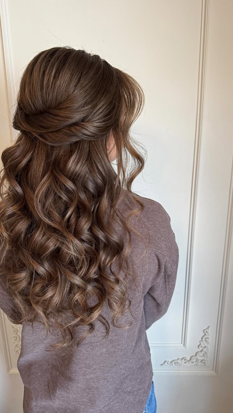 Long brown hair styled in cascading curls with a swept-back half-up section