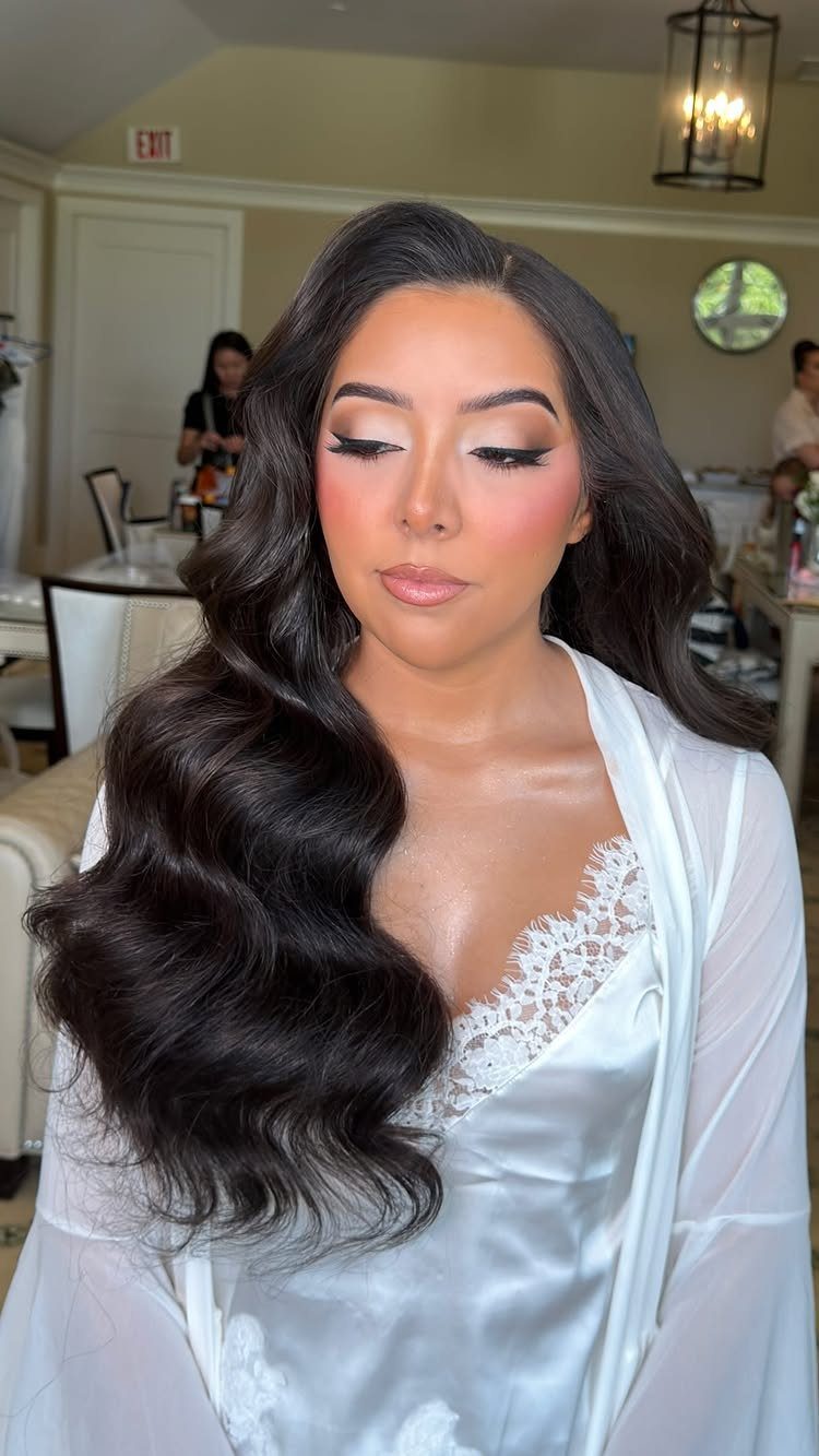 Bride in a satin robe wears long, glossy dark Hollywood waves