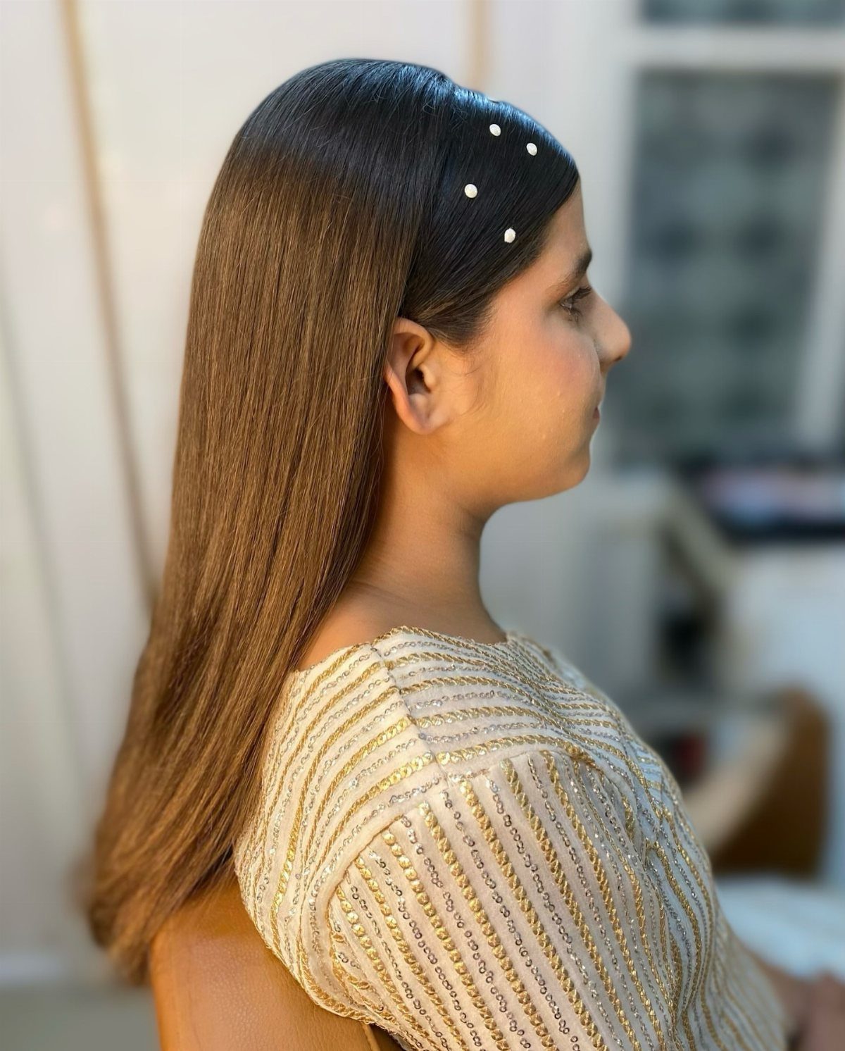 Woman with long straight hair styled with pearl pins for a wedding