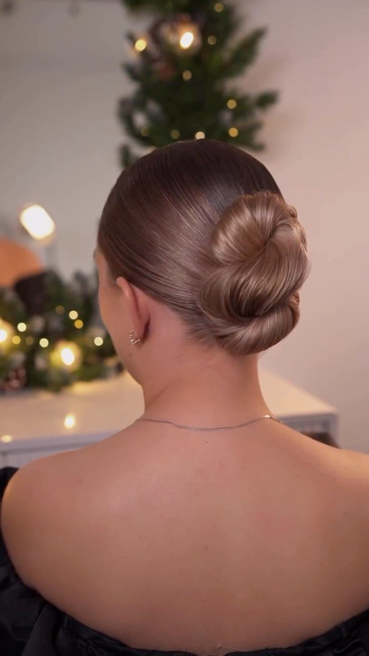 Glossy brown hair arranged in a smooth, swirled low updo