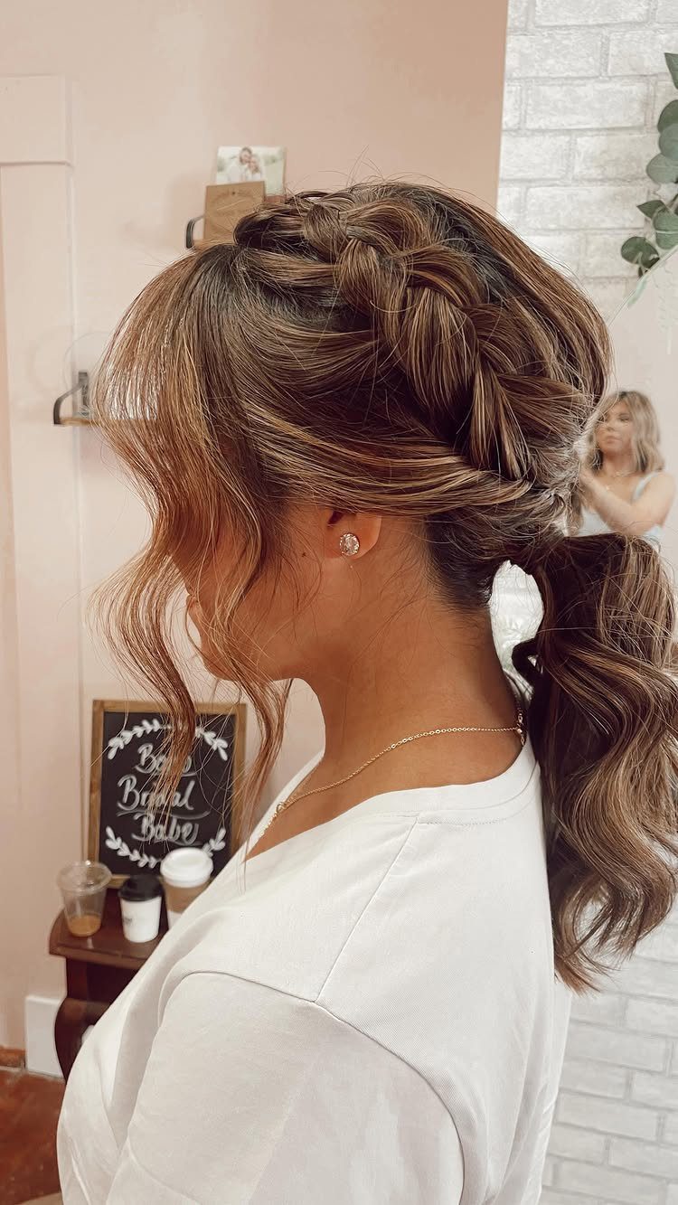 Brown braided updo with a long curled ponytail viewed from the side