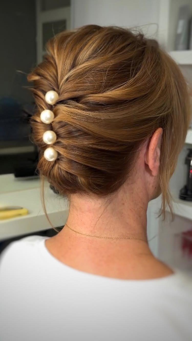 Auburn updo secured with a vertical row of pearl hair pins